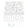 A white decorative panel with circular cutouts and a set of metal rings and plastic wall plugs. Náhled obrázku produktu