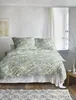 A bedroom scene with a bed dressed in floral bedding. Produktbild-Vorschau