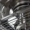A close-up view of the internal components of a heater, focusing on metal grates and a burner assembly. Produktbild-Vorschau