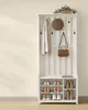A white wooden hall tree with a shelf for shoes and hooks for coats and accessories, set against a light yellow wall. Náhled obrázku produktu