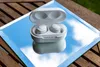 White wireless earbuds in their case, placed on a mirrored surface reflecting the sky, resting on a wooden table. Produktbild-Vorschau