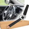 A steering wheel lock is shown attached to a car's steering wheel, with a separate view of the lock and its packaging in the foreground. Náhľad obrázku produktu