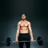 A muscular man is holding a barbell with weight plates. Náhled obrázku produktu