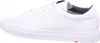 A side view of a white leather sneaker with a navy blue interior lining. Voir les images du produit