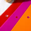 A close-up view of three flexible cutting mats in red, magenta, and orange, arranged diagonally. Voir les images du produit