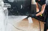 A person is using a pressure washer to foam a car in a garage. Náhľad obrázku produktu
