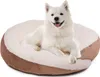 A white dog is lying on a round dog bed. Produktbild-Vorschau