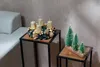 A Christmas advent wreath with gold candles and a decorative log with miniature Christmas trees are displayed on side tables next to a sofa. Anteprima dell’immagine prodotto