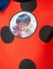 A close-up of a child's Ladybug costume with a circular image of the character Ladybug in the center. Produktbild-Vorschau