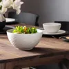 A salad bowl and a soup bowl are set on a wooden table, with a vase of flowers in the background. Podgląd zdjęcia produktu