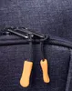 Close-up of a zipper on a dark blue fabric bag with two orange zipper pulls. Náhled obrázku produktu