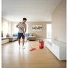 A man is mopping the floor in a modern living room. Produktbild-Vorschau