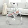 A baby is lying in a baby swing in a living room. Produktbild-Vorschau