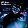 A person wearing a glowing LED mask in a dark, urban setting. Produktbild-Vorschau