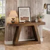 A console table with a lamp, artwork, and flowers in a hallway with wood-paneled walls. Produktbild-Vorschau