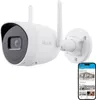 A white Hilook WLAN Bullet surveillance camera is mounted on a white wall bracket, with a smartphone displaying a surveillance app in the foreground. Podgląd zdjęcia produktu