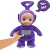A hand is holding a purple Teletubby plush toy. There is a speech bubble with text. Voir les images du produit