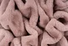 A close-up, abstract view of a soft, textured fabric, likely a blanket or throw, in a powder pink color. Produktbild-Vorschau
