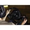 A person wearing headphones is playing a racing game using a steering wheel and controller. Podgląd zdjęcia produktu