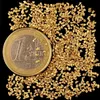 A pile of small gold nuggets next to a one euro coin. Produktbild-Vorschau