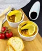 Two ramekins of food topped with lemon slices, served with cherry tomatoes and bread on a wooden board. Produktbild-Vorschau