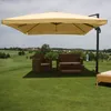 An outdoor patio set with a large umbrella on a grassy area with a village in the background.