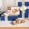 A wooden model truck kit and a completed model truck are displayed with gift-wrapped boxes. Náhľad obrázku produktu