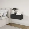 A black floating nightstand with a drawer, placed next to a bed. Voir les images du produit