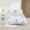 A neatly made bed with a winter-themed duvet cover and pillows, set against a white wall and a wooden slatted wall. Náhled obrázku produktu