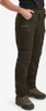 A person wearing brown and green outdoor pants and boots, shown from the waist down against a white background. Produktbild-Vorschau