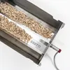 A stainless steel smoking tray filled with wood chips, with the brand name 'SKOTTI' visible. Produktbild-Vorschau