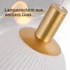Close-up view of a pendant lamp, focusing on the glass shade and gold-colored metal parts. Voir les images du produit