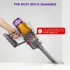 A hand holding a vacuum cleaner with dust leaking out, indicating a damaged dust bin. Produktbild-Vorschau