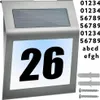 A solar-powered house number sign with the number 26 displayed prominently, along with mounting hardware and a set of customizable numbers and letters. Podgląd zdjęcia produktu