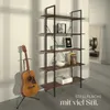 A bookshelf with items on it, next to a guitar on a stand. Náhled obrázku produktu