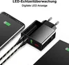 A close-up of a black dual-port USB charger with a digital display, plugged into a tablet and charging a smartphone. Anteprima dell’immagine prodotto