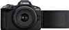 A black Canon EOS R50 mirrorless camera with its screen flipped out, shown from the front. Voir les images du produit