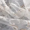 A close-up view of a sheer curtain with a floral pattern. Produktbild-Vorschau
