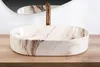 A marble-patterned vessel sink with a gold faucet sits on a wooden countertop, with a mirror reflecting the scene in the background. Náhľad obrázku produktu