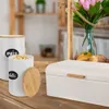 A kitchen counter with a bread box and storage containers, along with flowers in a vase. Podgląd zdjęcia produktu