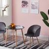 A small round dining table with two chairs in a room with pink walls and a window. Voir les images du produit