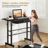 A woman is jogging on a treadmill next to a standing desk with a laptop. Anteprima dell’immagine prodotto