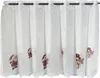 A white lace curtain with Christmas-themed figures. Produktbild-Vorschau
