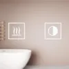 A close-up of a bathroom mirror cabinet with two illuminated icons on the wall. Náhled obrázku produktu