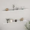 Two white wall shelves are mounted on a light gray wall, each displaying various decorative items. Náhled obrázku produktu