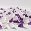 A pile of small, irregular crystals, some purple and some white, on a white background. Anteprima dell’immagine prodotto