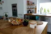 A kitchen island with a butter dish, fruit basket, and placemats. Podgląd zdjęcia produktu