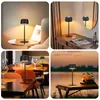 Collage of four images showing a black LED table lamp in different settings: on a side table, on a desk, on a restaurant table, and outdoors by a lake. Produktbild-Vorschau