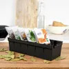A black spice organizer filled with spice packets sits on a wooden countertop, with bay leaves scattered around it. Anteprima dell’immagine prodotto