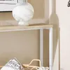 A close-up view of a console table with a decorative vase on top and pillows below. Anteprima dell’immagine prodotto
